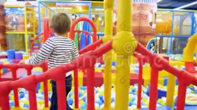 4k镜头4岁小男孩在购物中心五颜六色的大儿童游乐场玩耍和散步